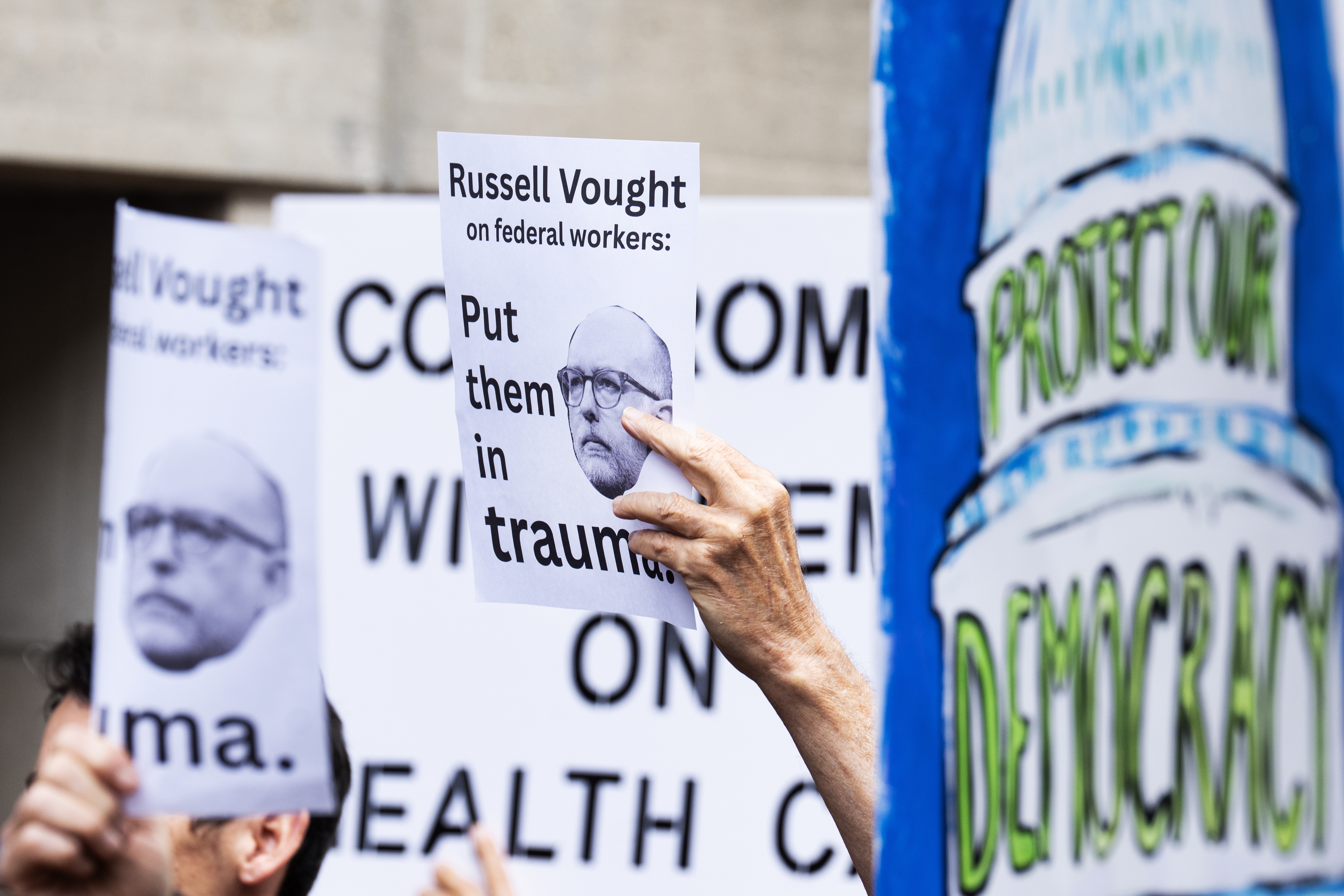 Signs with the image of Office of Management and Budget Director Russell Vought are seen during a news conference Congressional Democrats held to protest the Trump administration